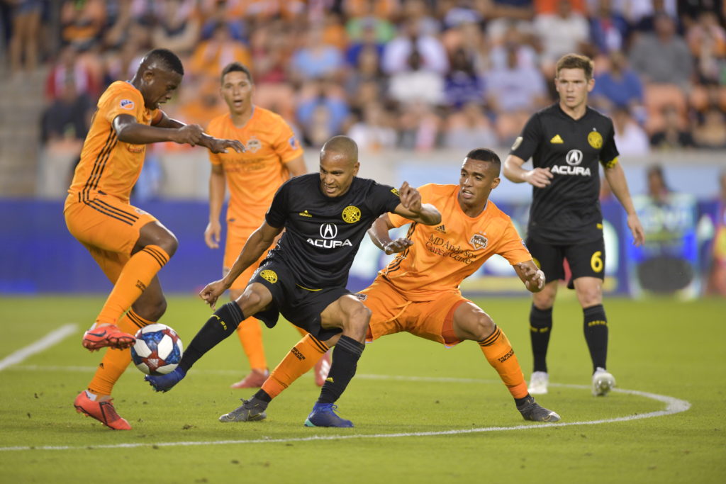 Ricardo Clark shields the ball from three Houston Dynamo defenders