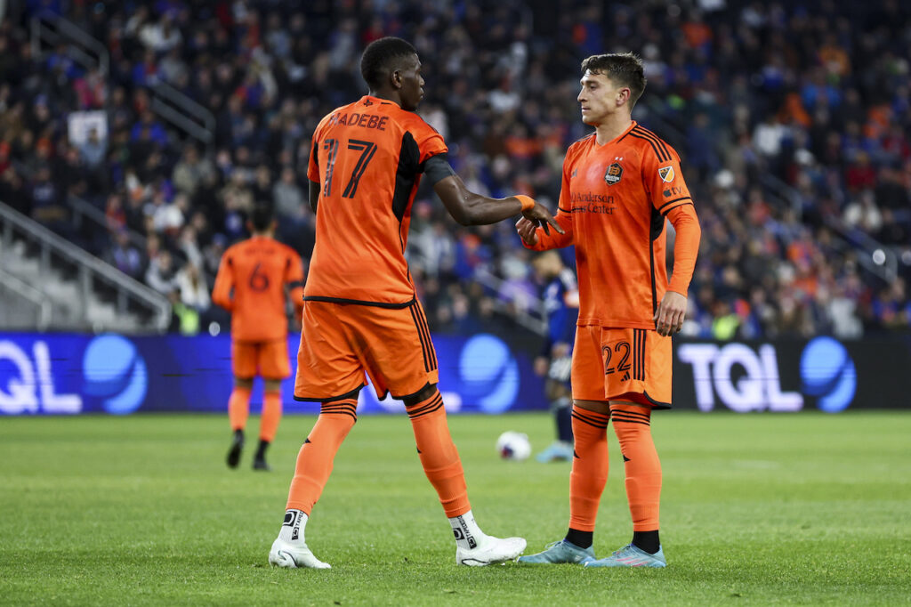 Houston Dynamo defender Tate Schmitt (right) celebrates with defender Teenage Hadebe (17) after scoring a goal against FC Cincinnati in the first half at TQL Stadium.